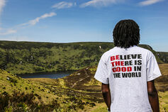 A student wearing a SPEA t-shirt looks at rolling hills in the distance.